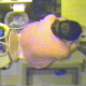 A woman with glasses is observed from a camera mounted above her as she wipes her ass after taking a dump. Poop is clearly seen on the toilet paper.